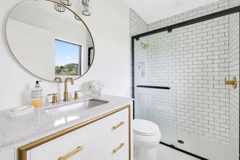 a bathroom with a granite countertop toilet sink and mirror