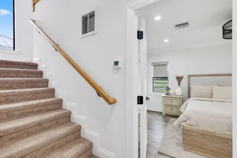 a view of entryway bedroom and hall with wooden floor