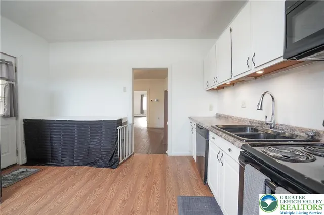 a view of a hallway with wooden floor and staircase