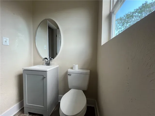 a bathroom with a toilet a sink and mirror