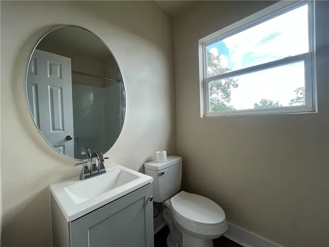 a bathroom with a toilet sink and mirror