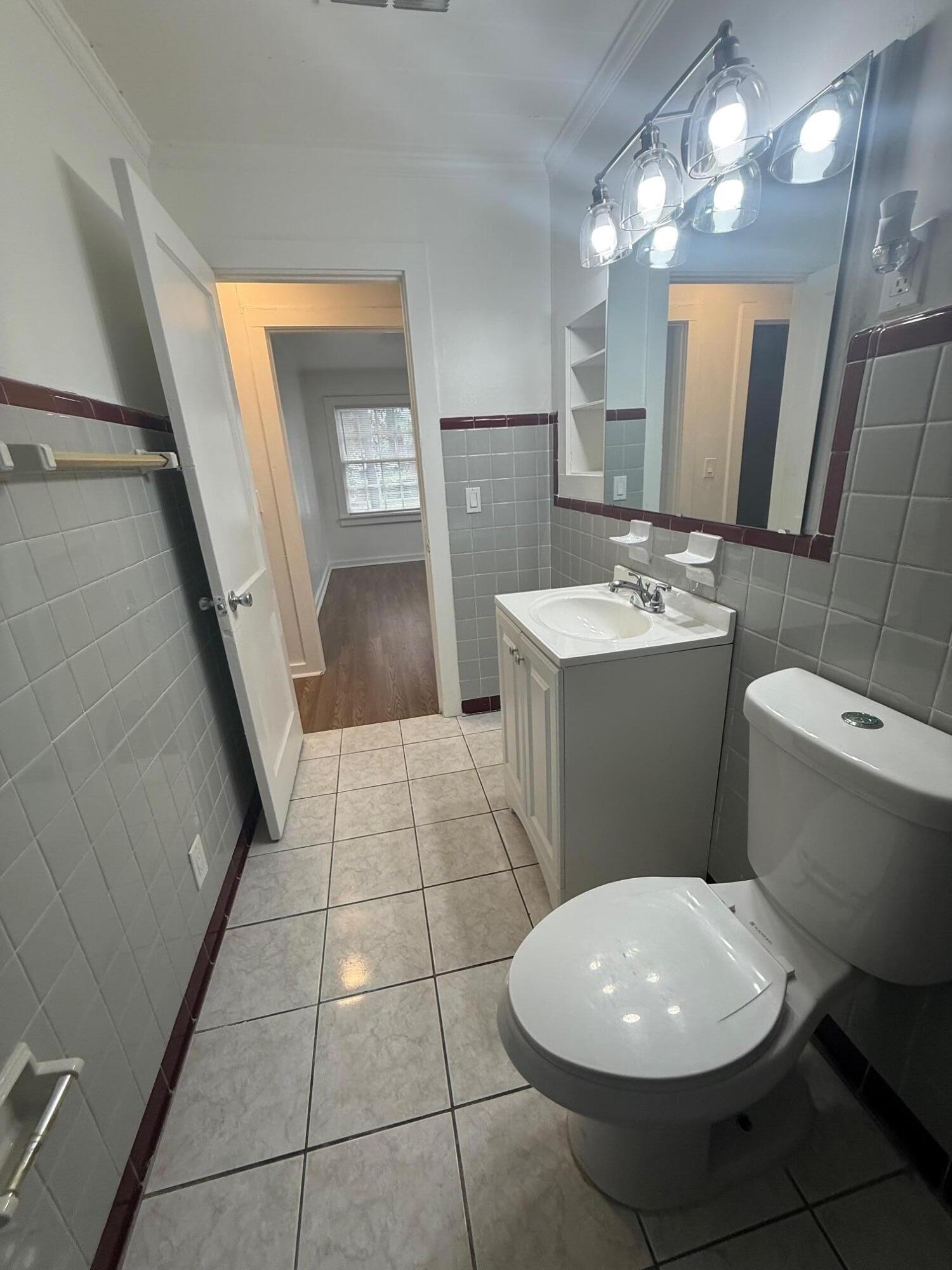 33 Southwest 12th Avenue Delray Beach, FL 33444 - Photo 16 of 17 a bathroom with a sink a toilet a mirror and vanity