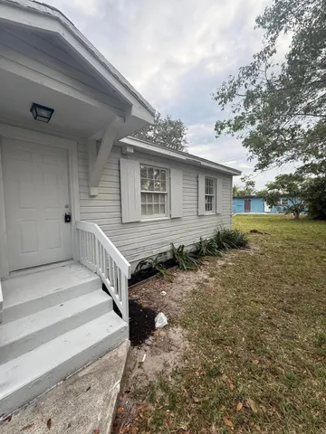 a view of house with backyard and trees