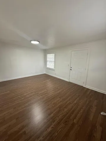 a view of an empty room and wooden floor