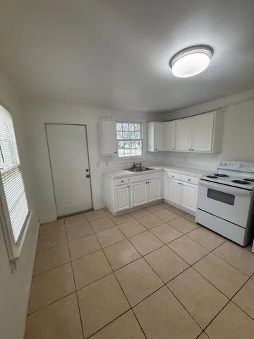 a kitchen with granite countertop cabinets and window