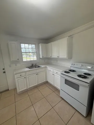 a kitchen with a stove sink and cabinets