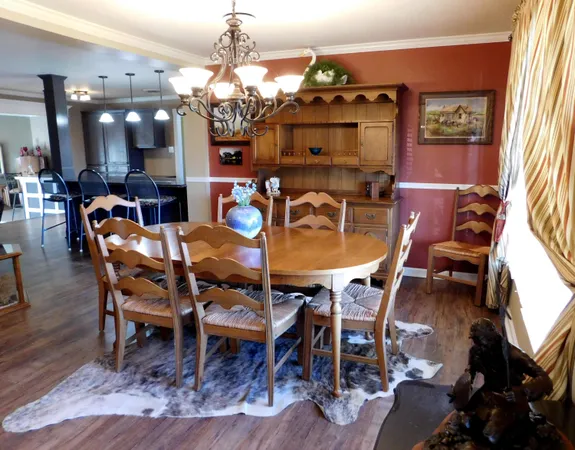 a dining room with furniture a chandelier and wooden floor