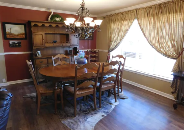a dining room with furniture a chandelier and wooden floor