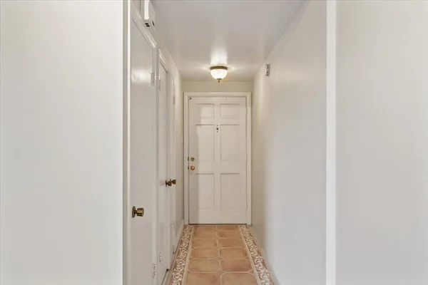 a view of a hallway with wooden floor and a bathroom