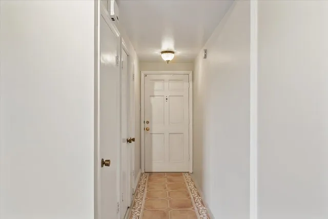 a view of a hallway with wooden floor and a bathroom