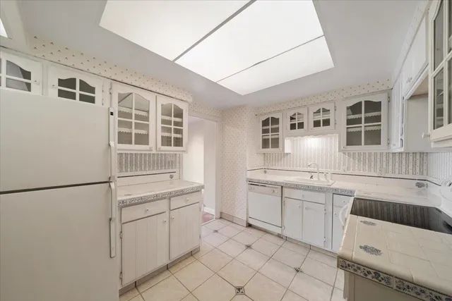 a kitchen with white cabinets and white appliances