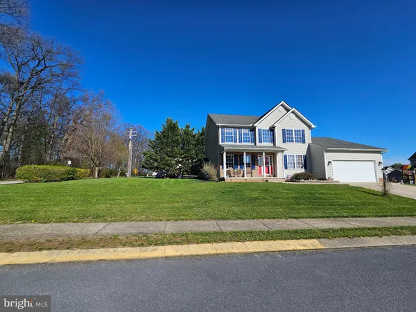 a view of a house with a big yard plants and large trees
