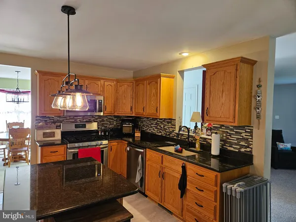 a kitchen with granite countertop a sink stove and cabinets