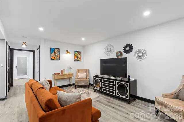 a living room with furniture a flat screen tv and a window
