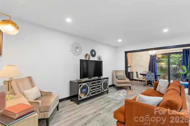 a living room with furniture a flat screen tv and a large window