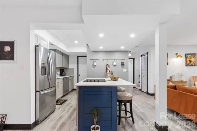 a kitchen with stainless steel appliances kitchen island granite countertop a refrigerator and a sink