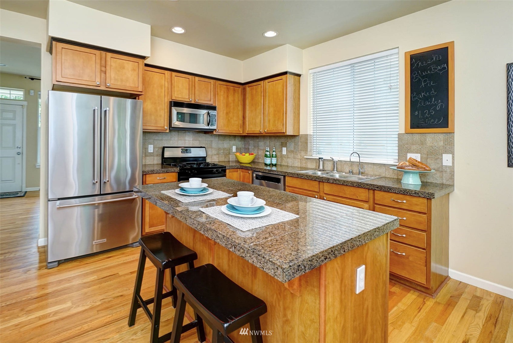 23914 33rd Drive Southeast Bothell, WA 98021 - Photo 6 of 28 a kitchen with stainless steel appliances granite countertop a refrigerator a stove a sink a dining table and chairs