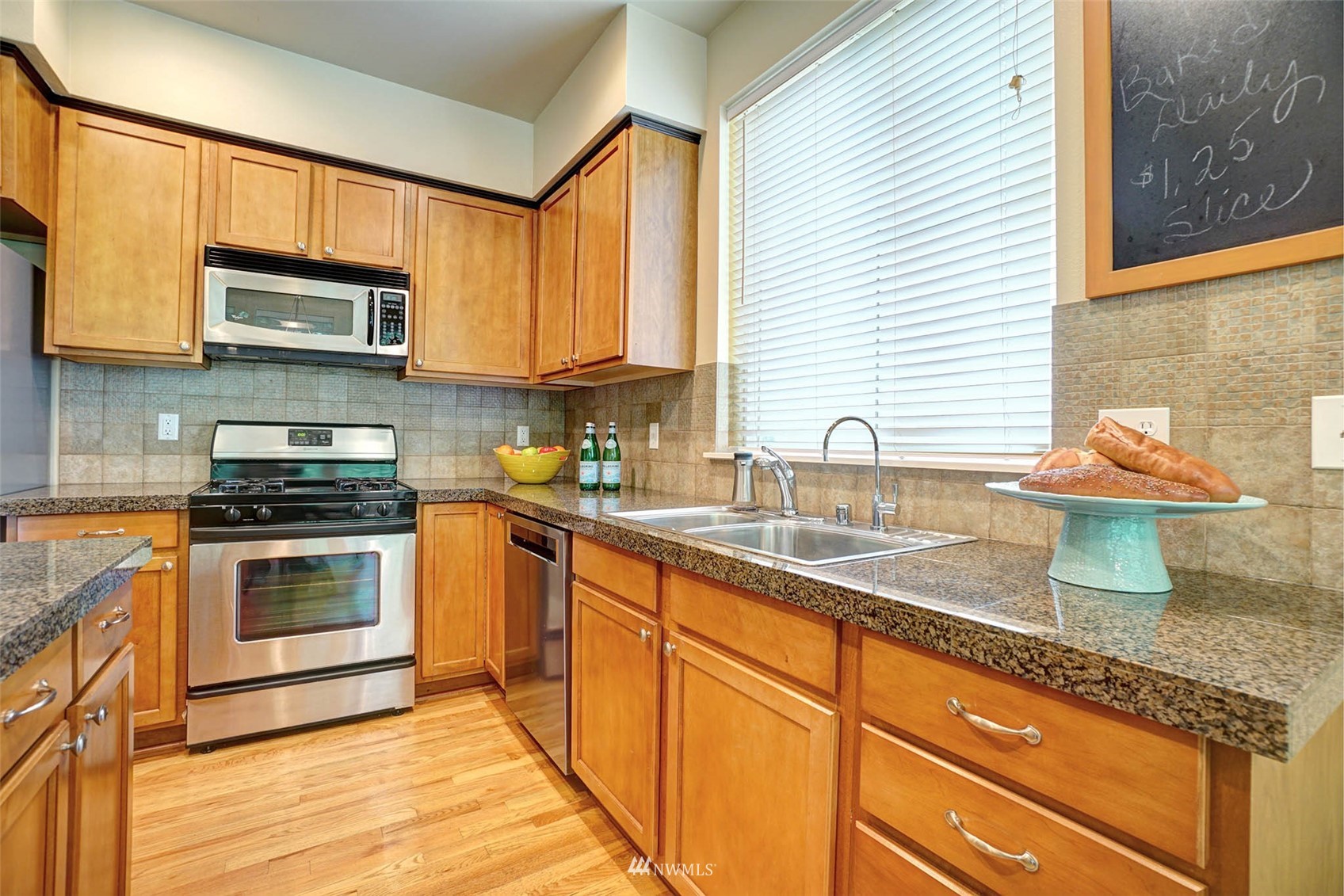 23914 33rd Drive Southeast Bothell, WA 98021 - Photo 7 of 28 a kitchen with granite countertop a sink cabinets stainless steel appliances and a window