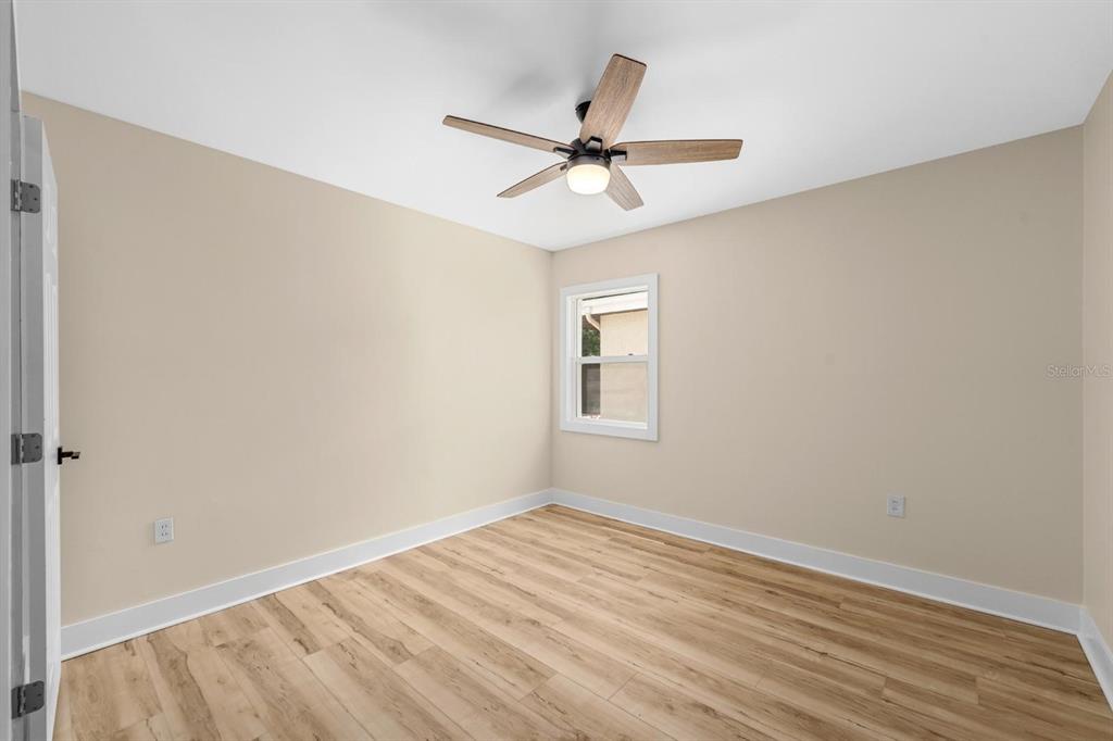 10707 North Rome Avenue Tampa, FL 33612 - Photo 13 of 35 a view of a room with wooden floor and a ceiling fan