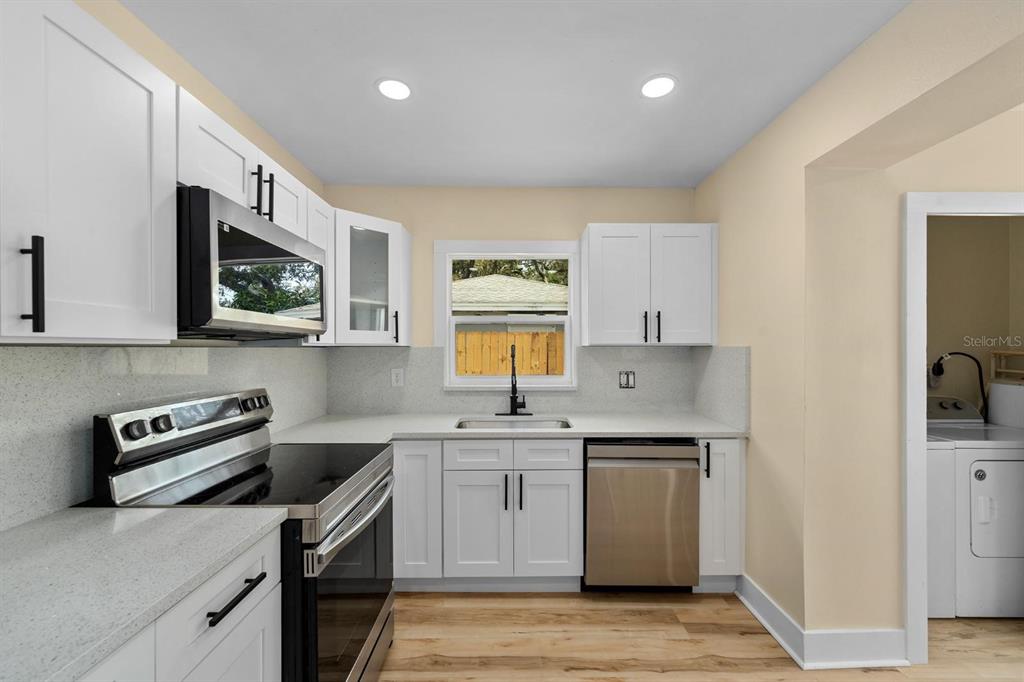10707 North Rome Avenue Tampa, FL 33612 - Photo 28 of 35 a kitchen with a sink a stove and cabinets