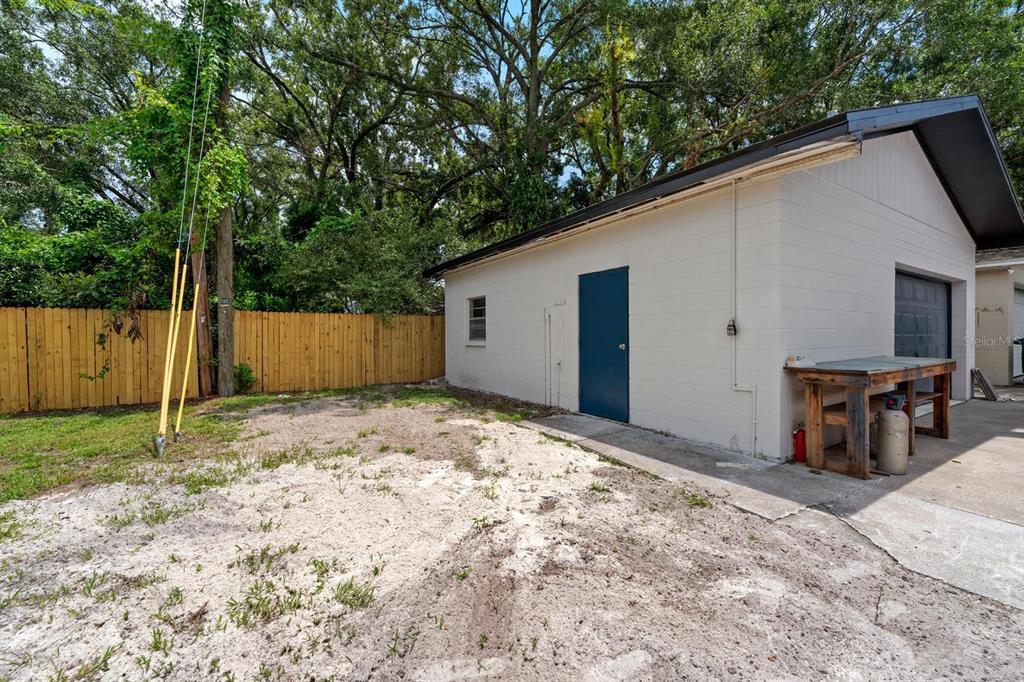 10707 North Rome Avenue Tampa, FL 33612 - Photo 35 of 35 a backyard of a house with wooden fence and trees