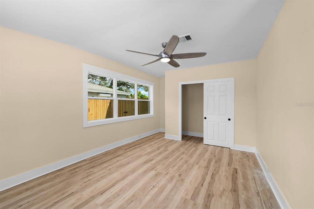 10707 North Rome Avenue Tampa, FL 33612 - Photo 8 of 35 a view of an empty room with a window and wooden floor