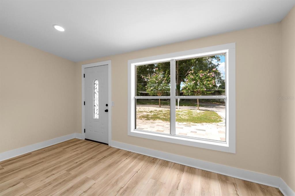10707 North Rome Avenue Tampa, FL 33612 - Photo 9 of 35 an empty room with wooden floor and windows