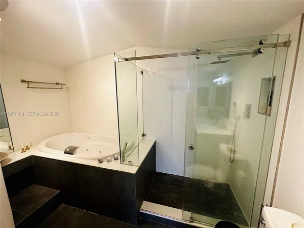a bathroom with a tub shower sink and toilet