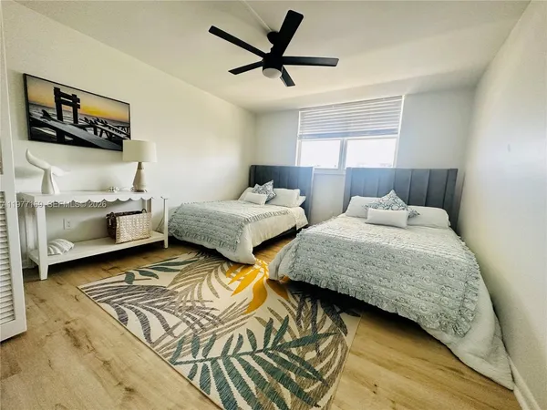 a bedroom with two beds and a ceiling fan