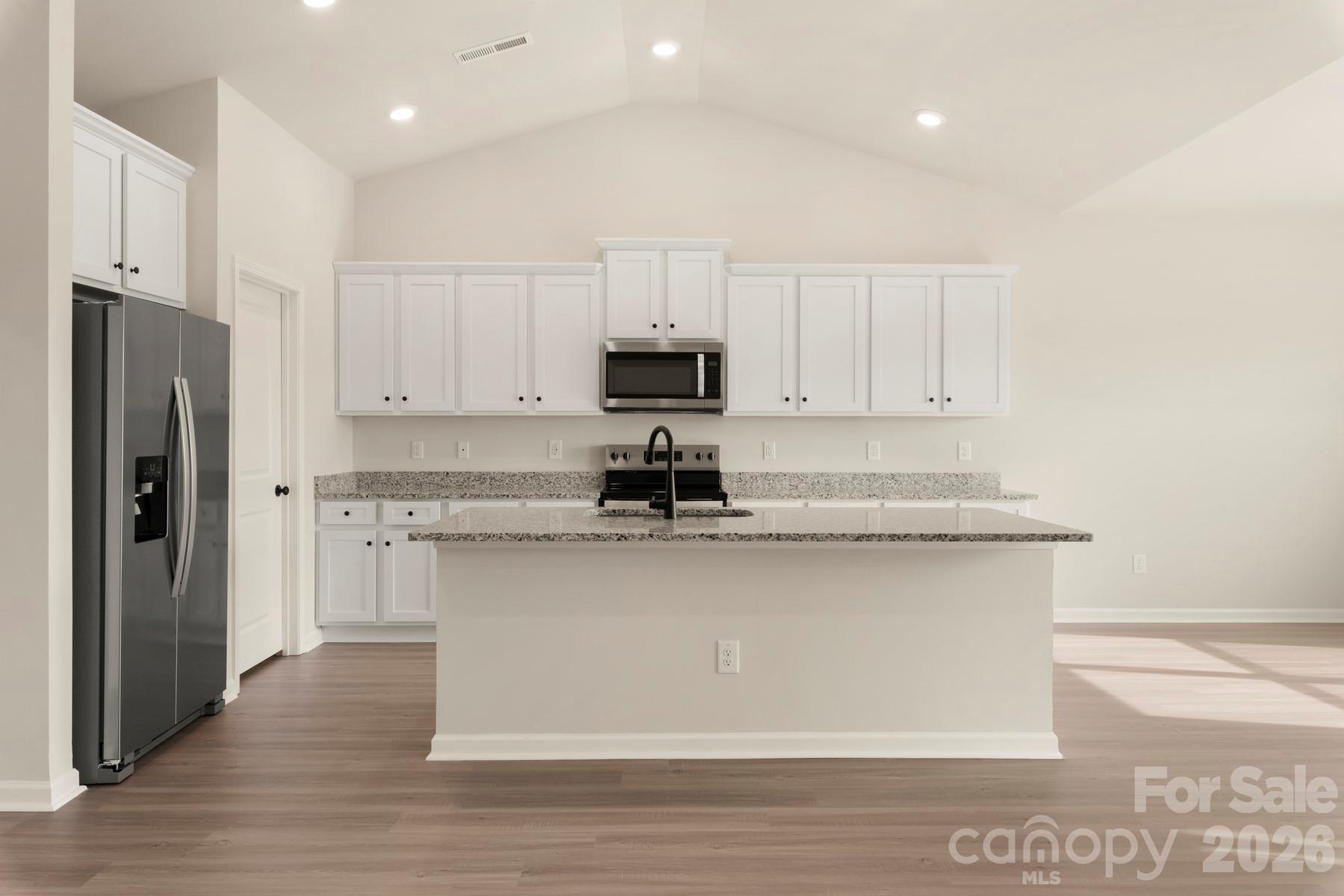 275 Limestone Terrace Salisbury, NC 28146 - Photo 7 of 22 a kitchen with stainless steel appliances granite countertop a stove a refrigerator a sink and white cabinets with wooden floor