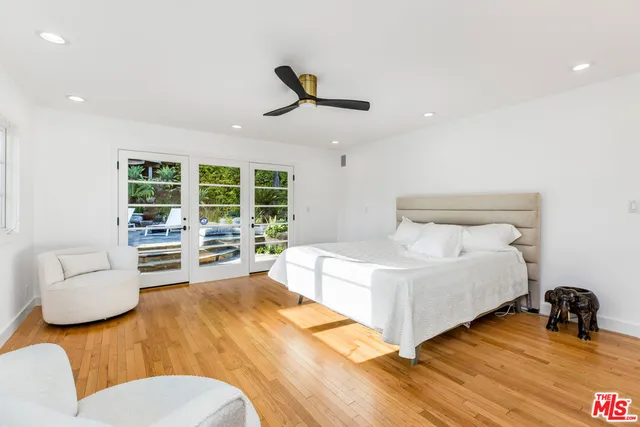 a spacious bedroom with a bed a couch and a large window