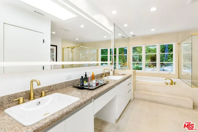 a bathroom with a granite countertop sink and large mirror
