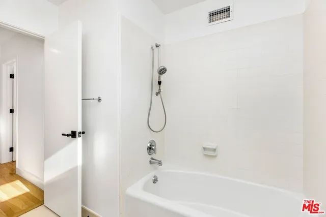 a bathroom with a bath tub with a shower