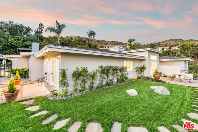 a view of a house with backyard and sitting area