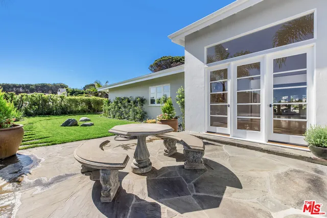 a view of a patio with table and chairs with wooden fence