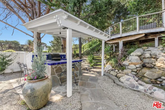a view of a patio with table and chairs potted plants