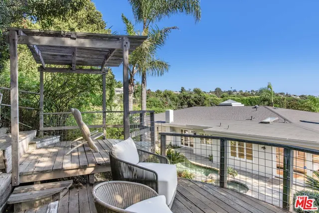 a view of a patio with couches chairs and wooden floor