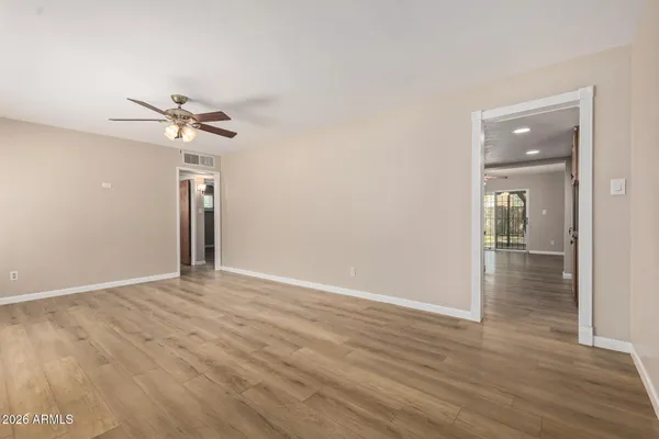a view of an empty room with a window and wooden floor