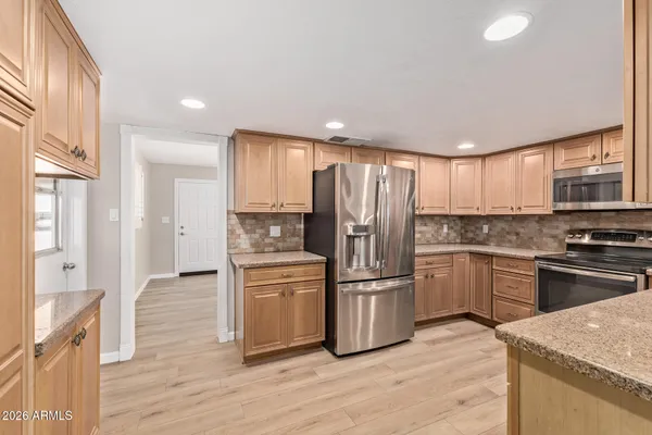 a kitchen with granite countertop a sink stainless steel appliances and cabinets