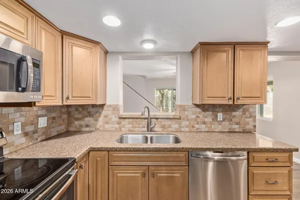 a kitchen with stainless steel appliances granite countertop a refrigerator and a sink