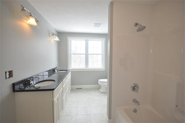 1136 Hill Road, Unit A Boxborough, MA 01719 - Photo 16 of 16 a bathroom with a granite countertop sink a toilet and bathtub