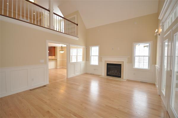 1136 Hill Road, Unit A Boxborough, MA 01719 - Photo 6 of 16 an empty room with wooden floor fireplace and windows