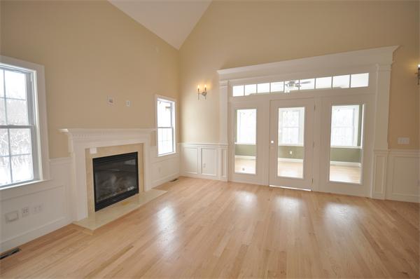 1136 Hill Road, Unit A Boxborough, MA 01719 - Photo 8 of 16 a view of an empty room with wooden floor fireplace and a window