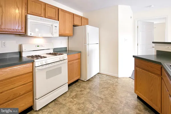 a kitchen with white cabinets and white appliances