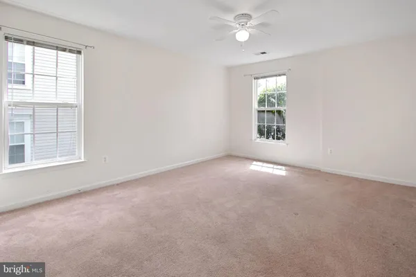 an empty room with a window and ceiling fan