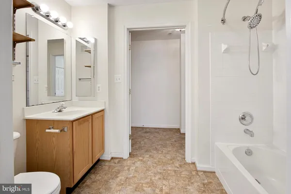 a bathroom with a tub sink and mirror
