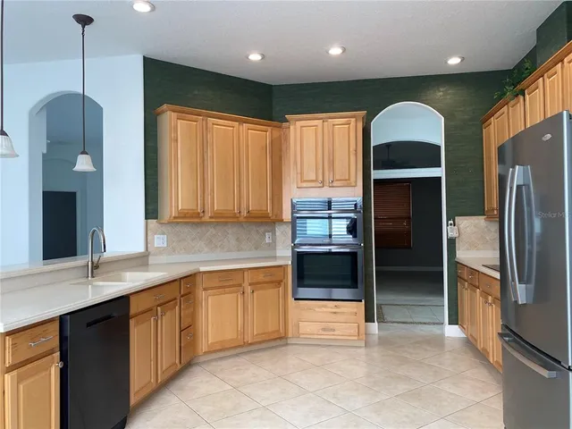 a kitchen with stainless steel appliances granite countertop a refrigerator and a sink