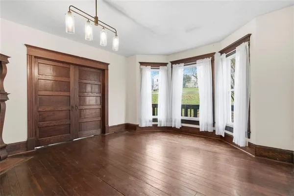wooden floor fireplace and windows in an empty room