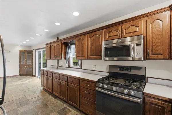 a kitchen with stainless steel appliances granite countertop a sink stove and cabinets