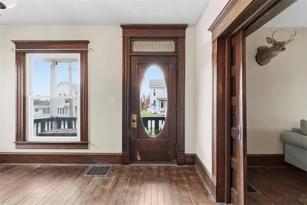 a view of a hallway with wooden floor and a livingroom